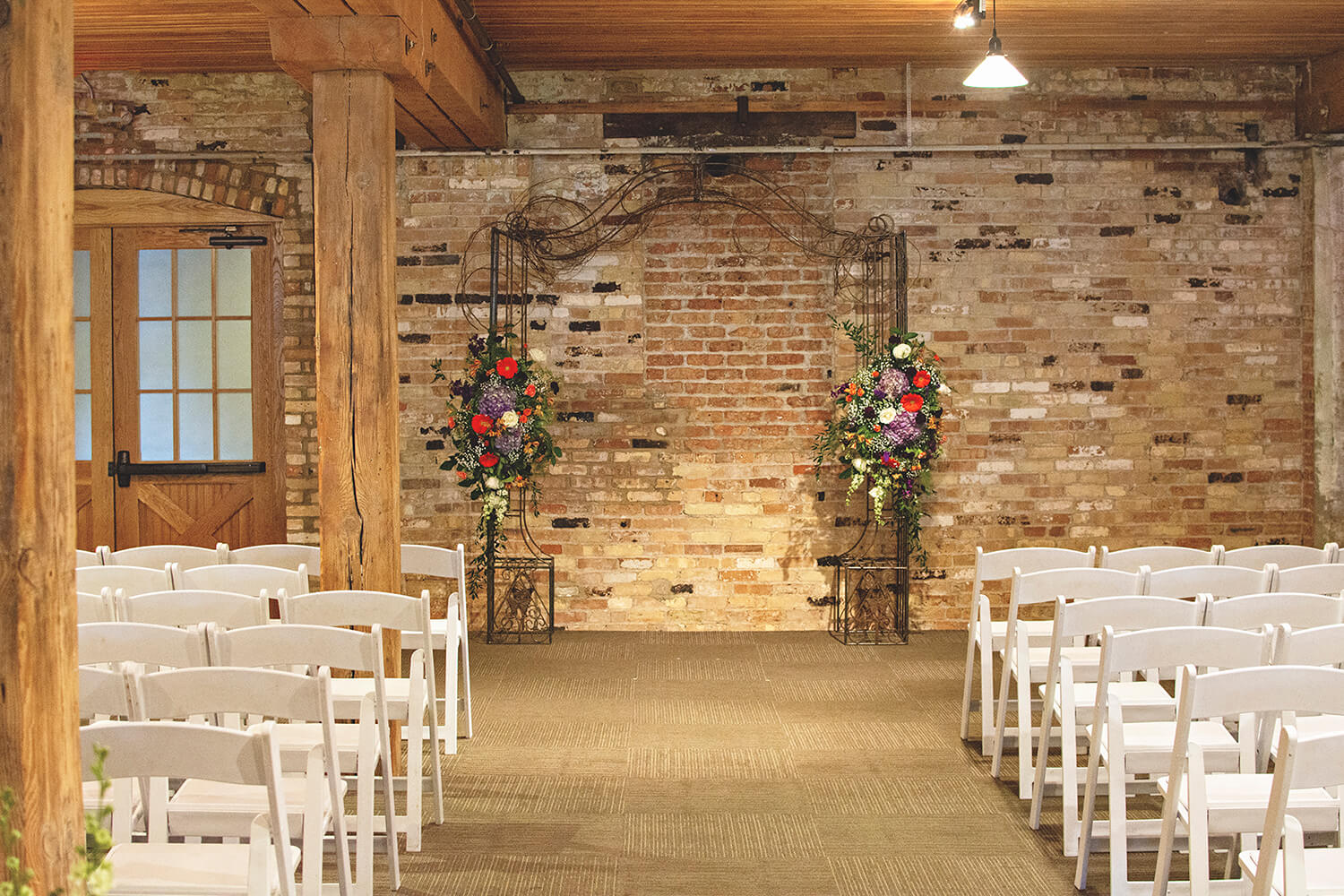 metal arch with floral decoration used at an indoor wedding at Prairie St. Brewing Co. in Rockford, IL