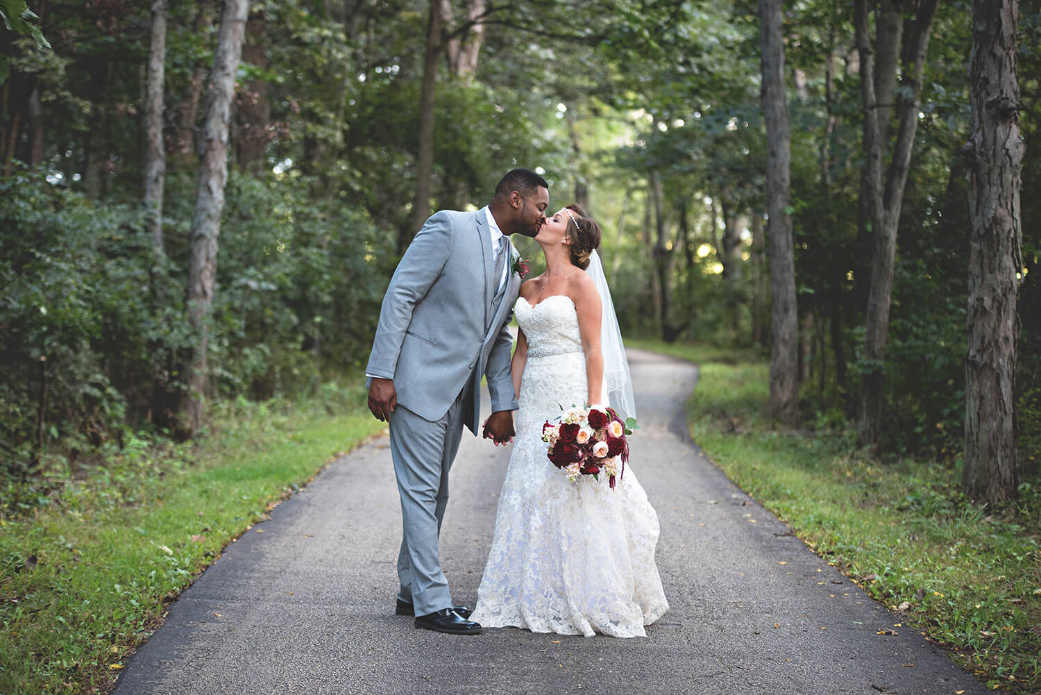 Wedding couple kiss on the trail at Kilbuck Creek in Monroe Center, IL
