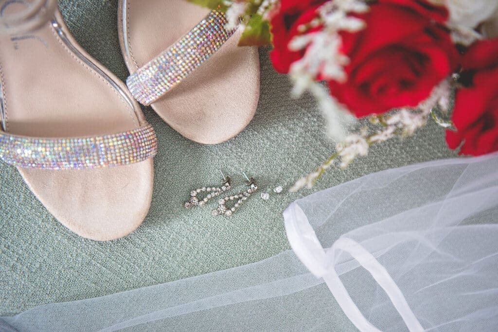 Brides shoes, jewelry, veil, and flower details.