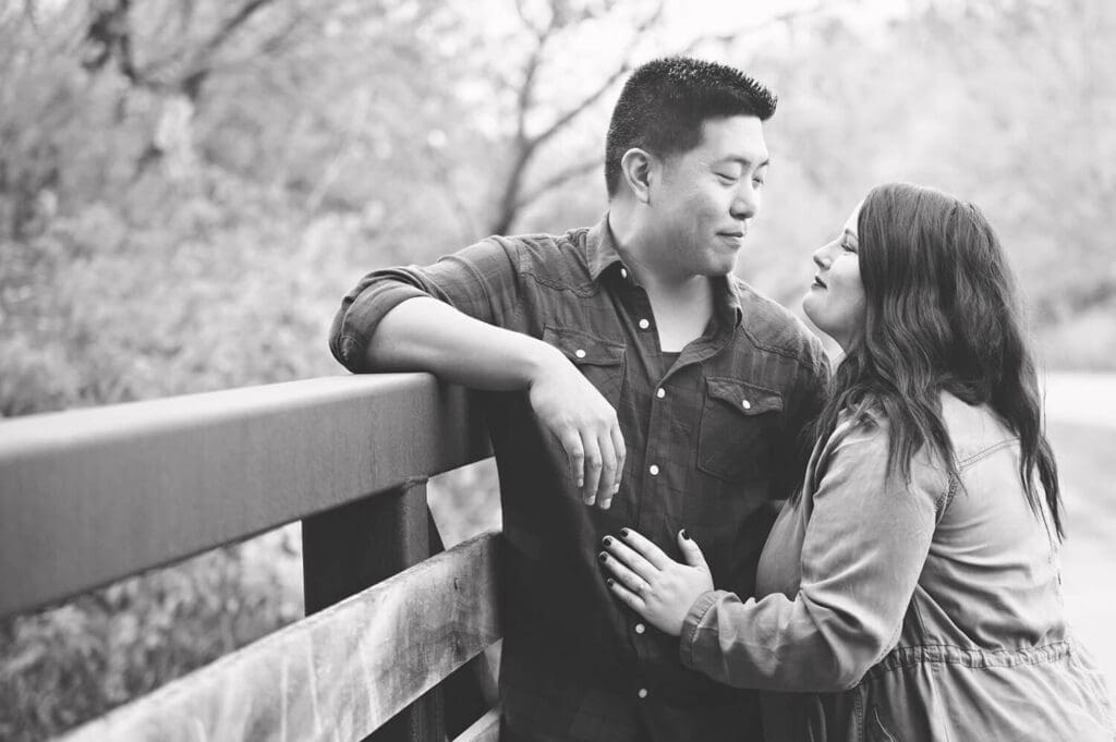 engaged couple embrace on a bridge at Rock Cut State Park in Caledonia, IL