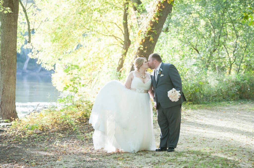 Bride and Groom take wedding portraits near a river in Northern Illinois