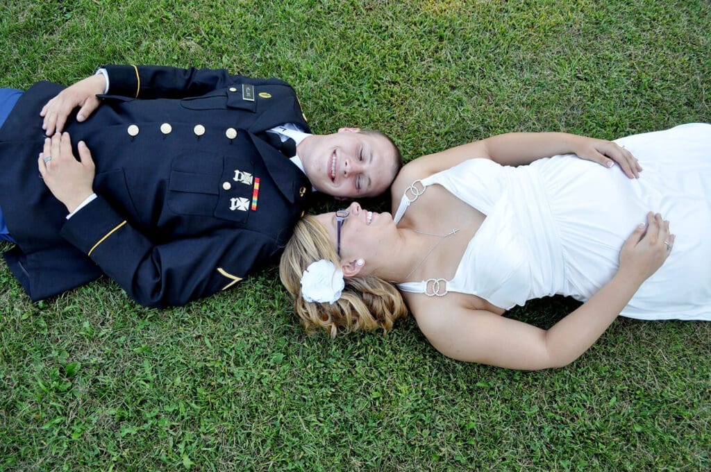 bride and groom lay in grass smiling during their wedding day