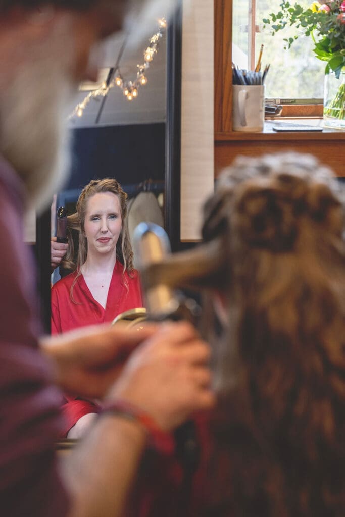 bride gets hair done on wedding morning