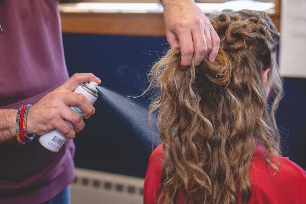 hair spray being sprayed on bride's hair