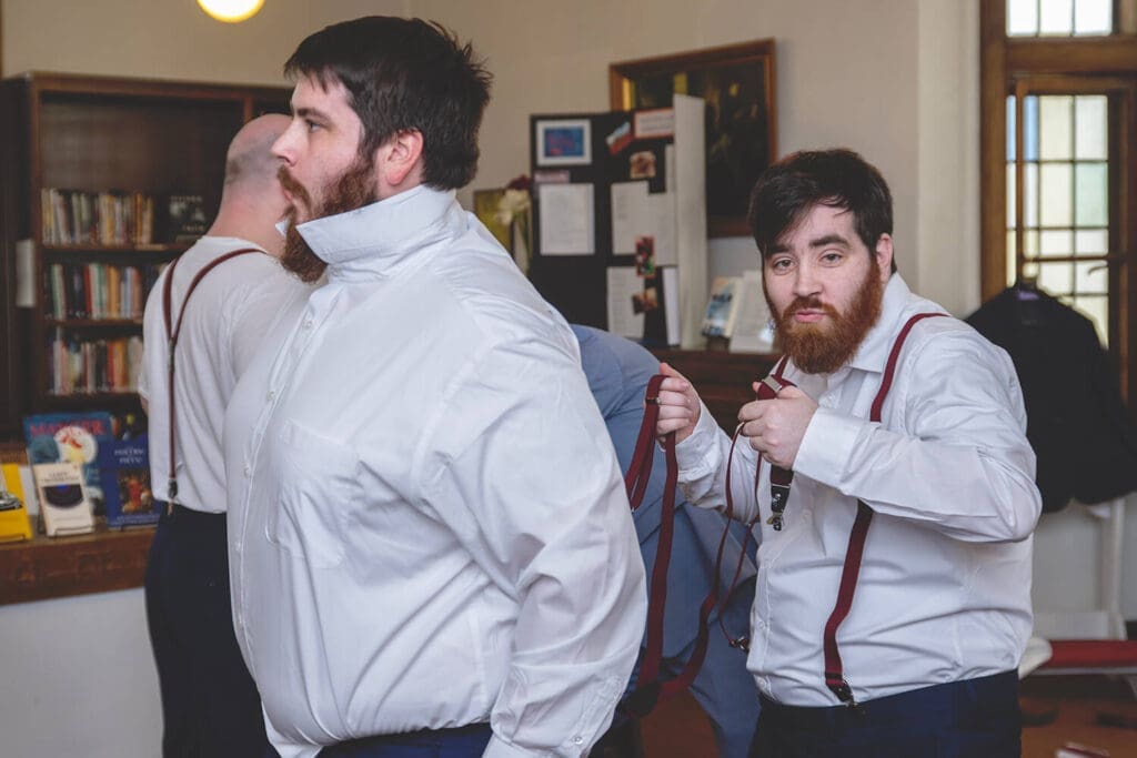 groomsmen helping groom get ready
