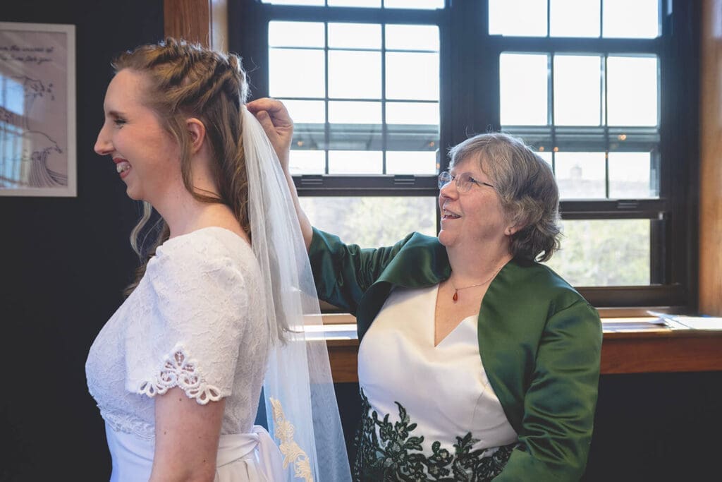 mother of bride helps with brides veil