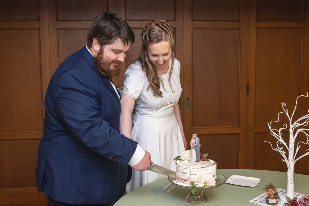 bride and groom cut wedding cake