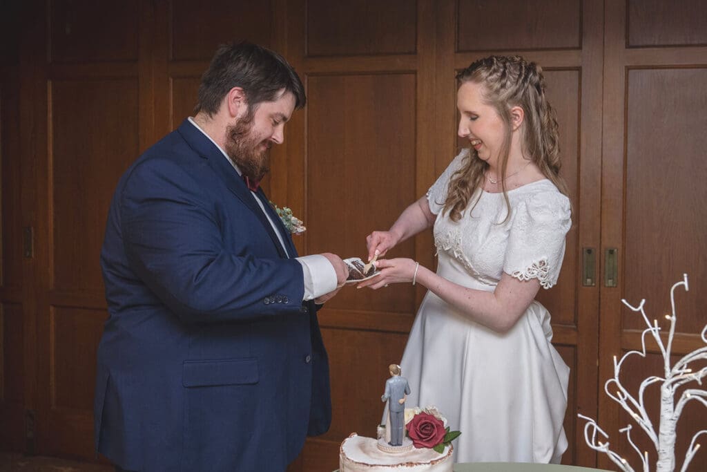 bride and groom use forks on wedding cake