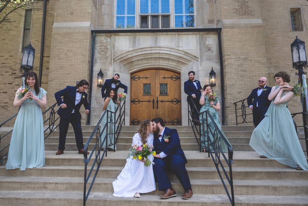 wedding party poses with bride and groom during wedding portraits