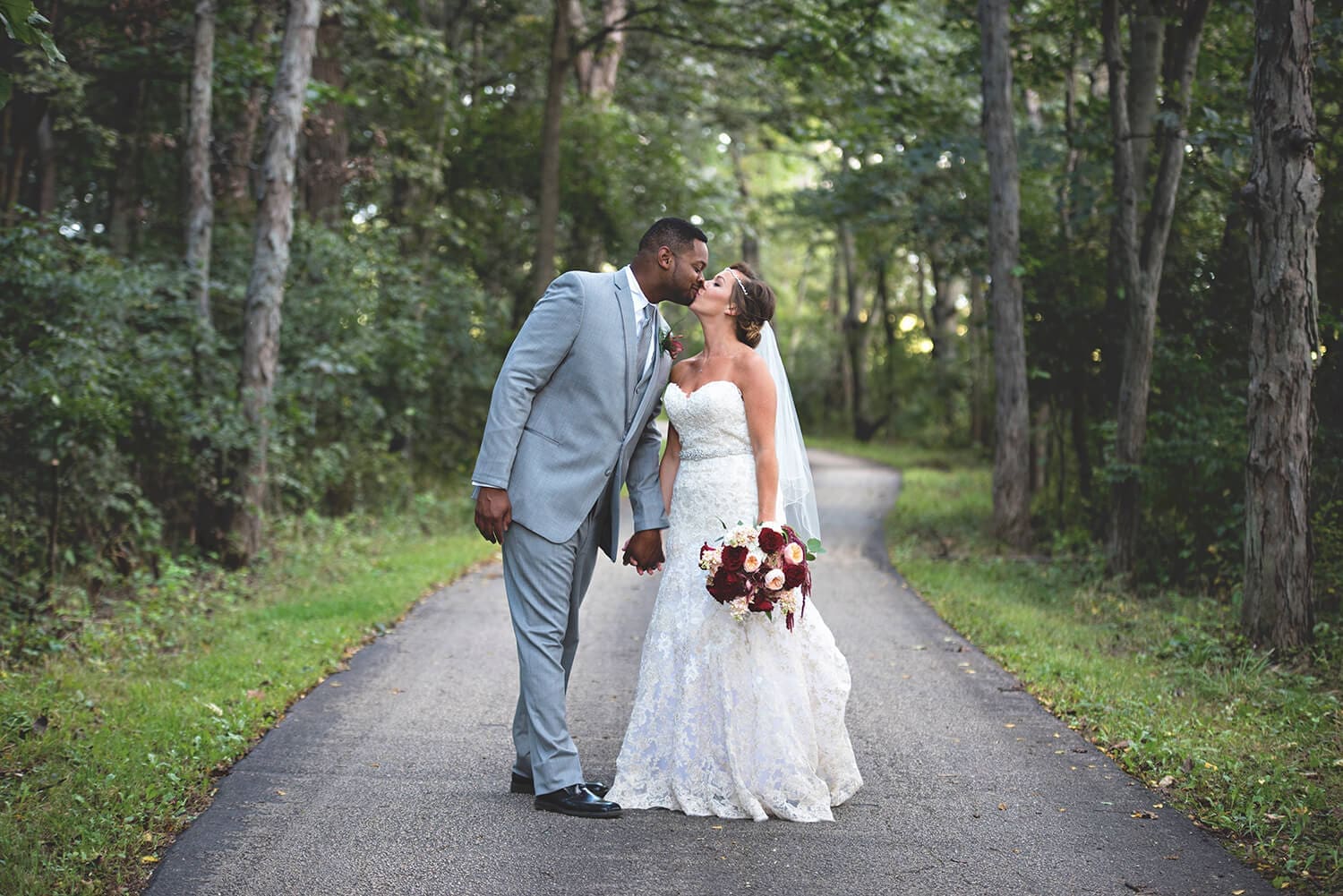 Wedding couple kiss on the trail at Kilbuck Creek in Monroe Center, IL