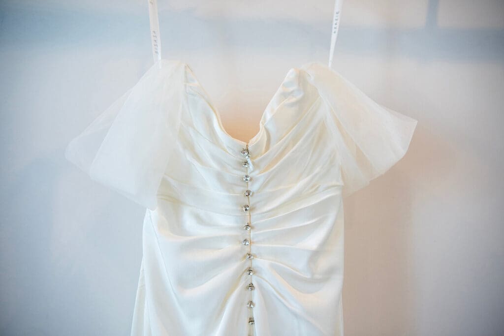 Wedding dress hanging on a wall.