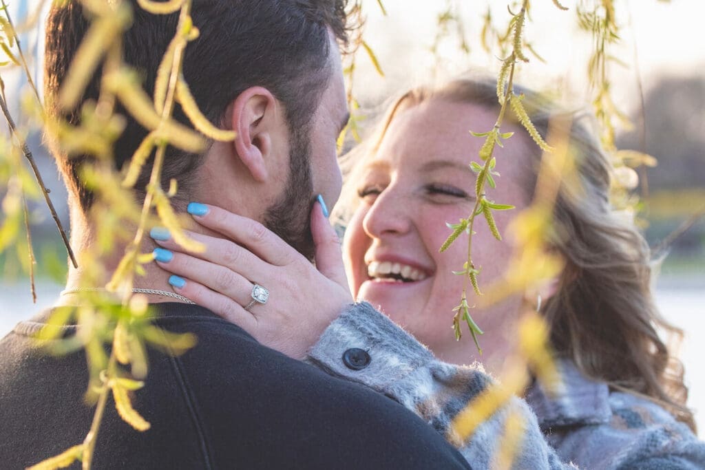 Engaged couple take engagement photos with focus on ring