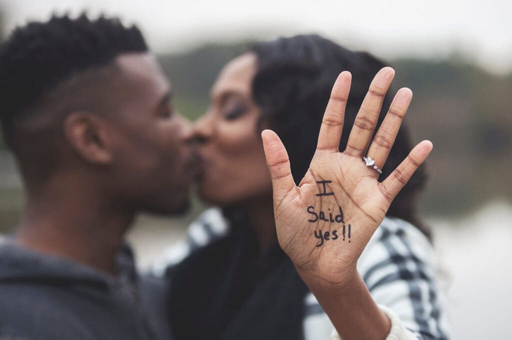 engaged couple take portraits with I Said Yes on bride's hand