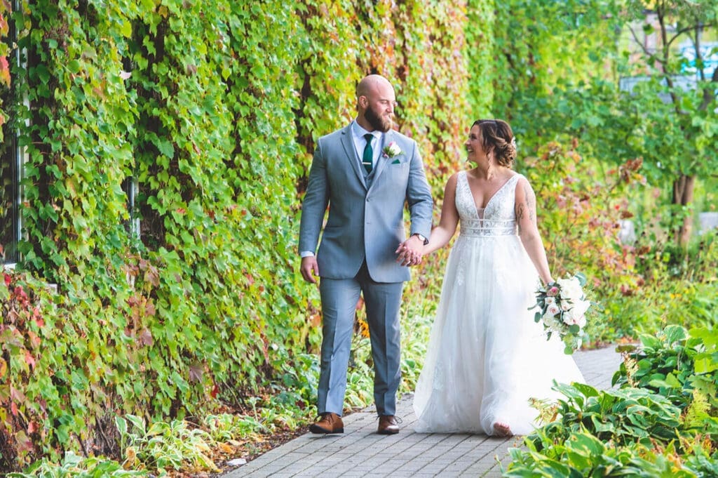 Bride and groom stroll sidewalk outside of Starline Factory in Harvard, IL