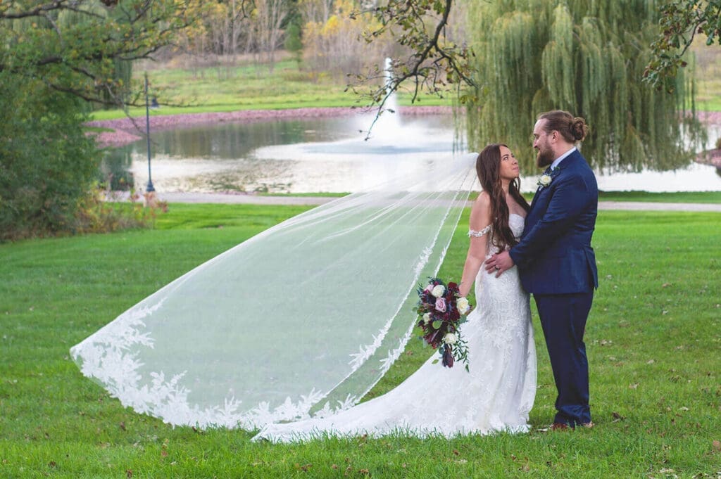 Wedding couple pose in front of fountain at The Pavilion at Orchard Ridge Farms in Rockton, IL