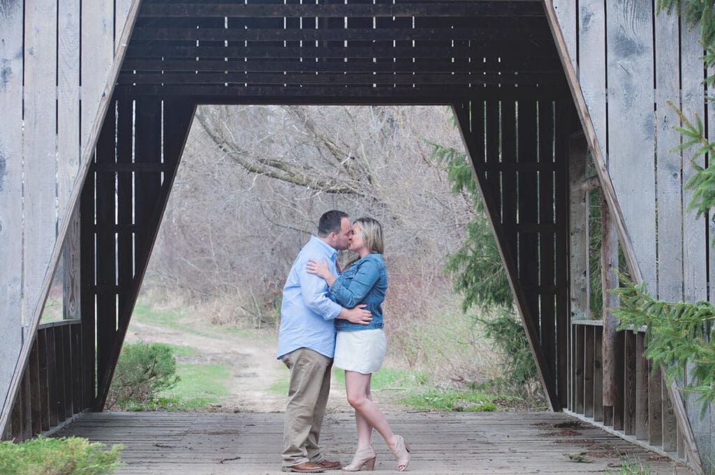Engaged couple take engagement photos on bridge at Williams Tree Farm in Rockton, IL